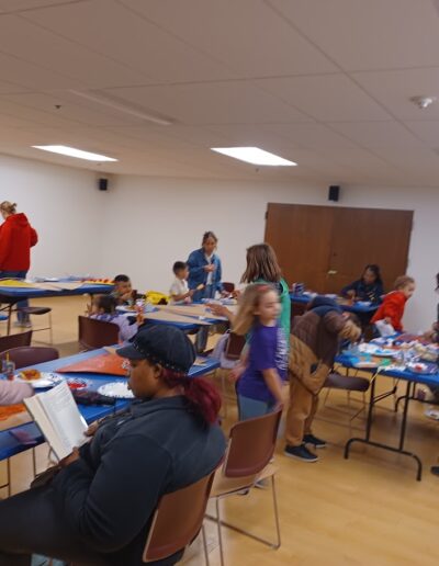 Kids and parents working during giant pizza painting program
