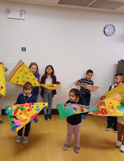 Kids showing finalized work for giant pizza painting program