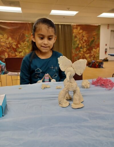 Girl showing an elephant clay work during a craft program at the library.