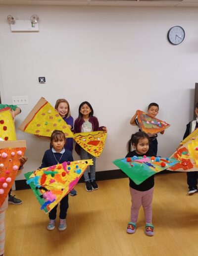 Kids showing finalized work for giant pizza painting program