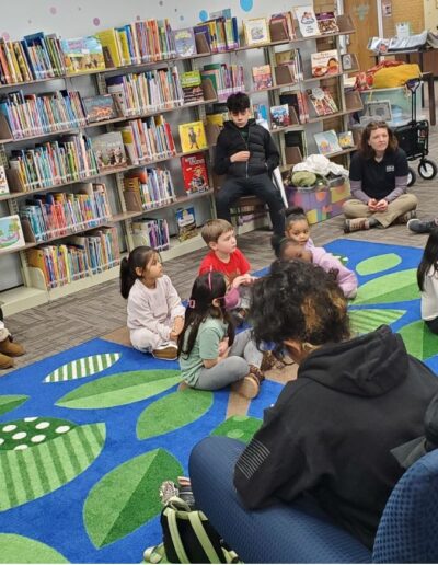 Storytime with a librarian reading to kids sitting on the floor